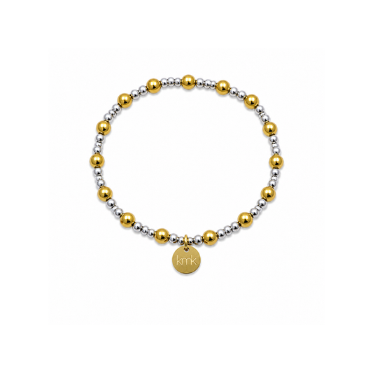 A beaded stretch bracelet featuring alternating polished gold and matte silver metallic beads, with a small round gold disc charm engraved with 'KITK' at the bottom center, shown on a plain white background.