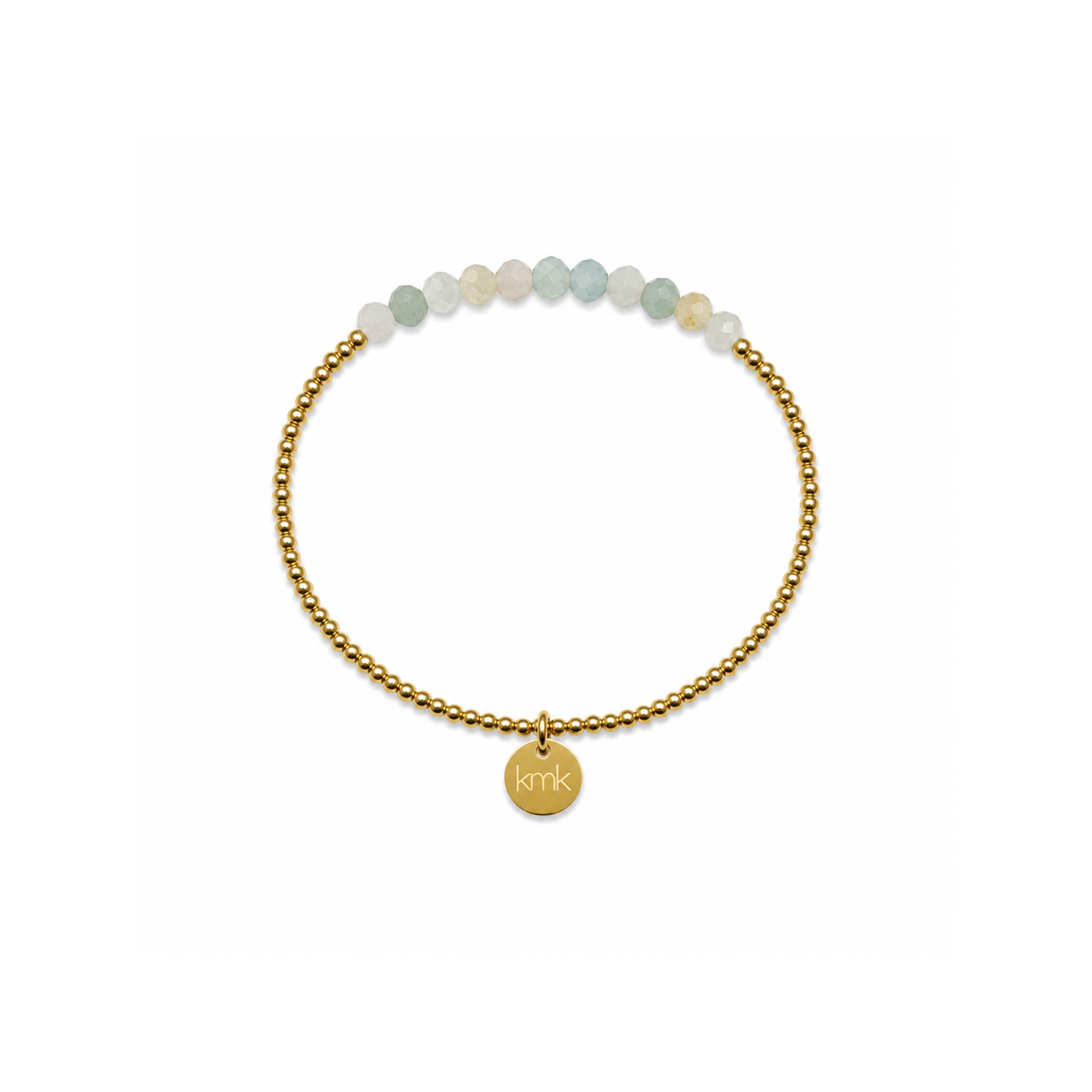 A delicate gold beaded bracelet with a small round gold charm engraved with 'KMK', accented by a row of pale green and white beads at the top, shown on a plain white background.