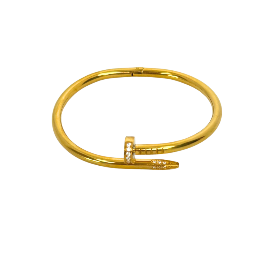 Gold nail bangle bracelet with a unique design on a white background