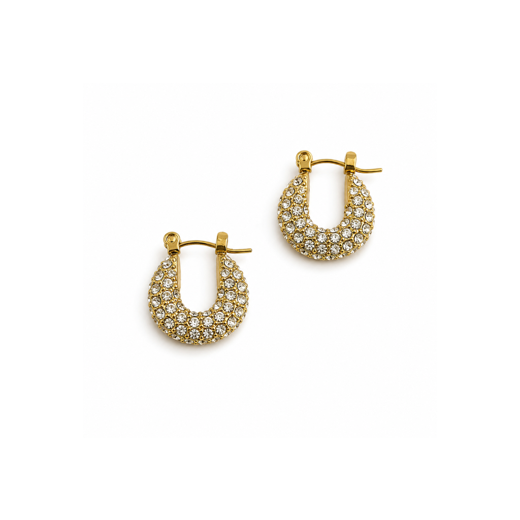 A pair of gold crescent-shaped hoop earrings paved with small clear stones, displayed on a clean white background.