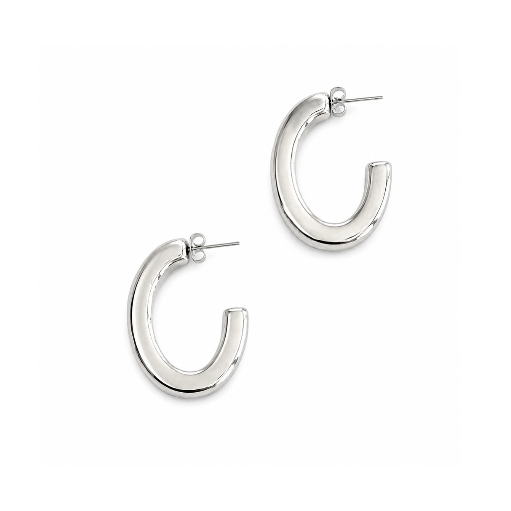 A pair of polished silver crescent-shaped hoop earrings with post backings, displayed on a clean white background.