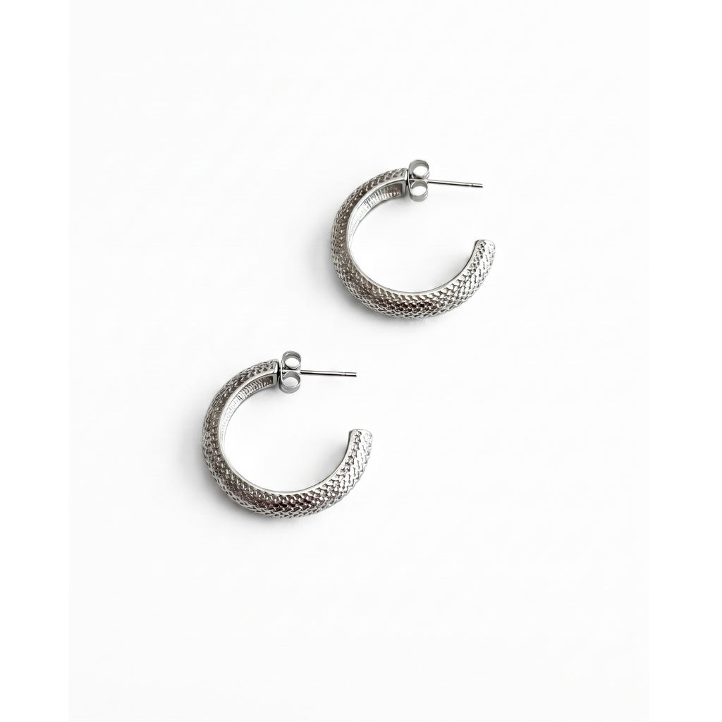 A pair of textured silver half-hoop earrings with post backs, displayed on a clean white background.
