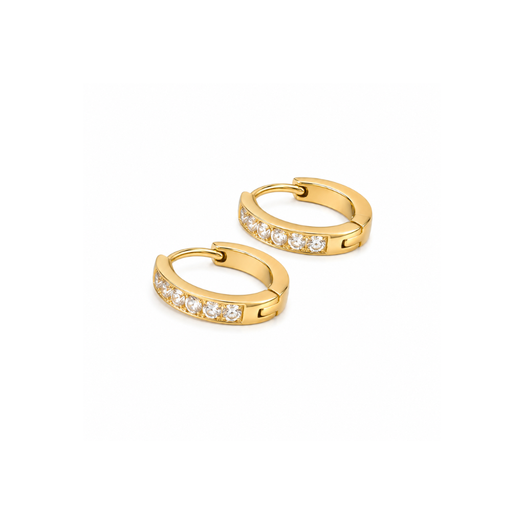 A pair of small gold huggie hoop earrings, each set with a row of clear round-cut stones on the front band, photographed on a clean white background.