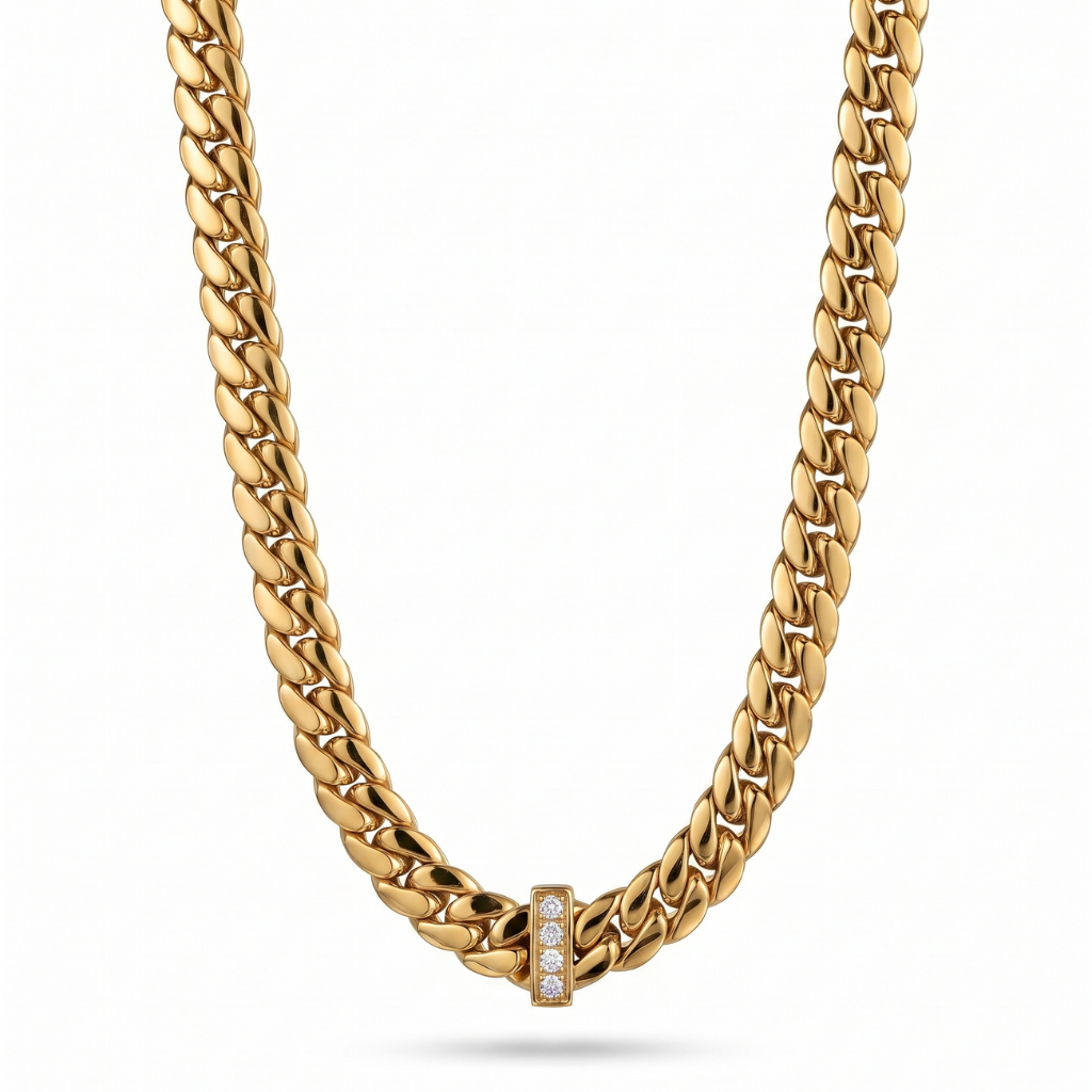A gold Cuban link chain necklace with a small rectangular gold clasp set with clear stones, shown against a plain white background.