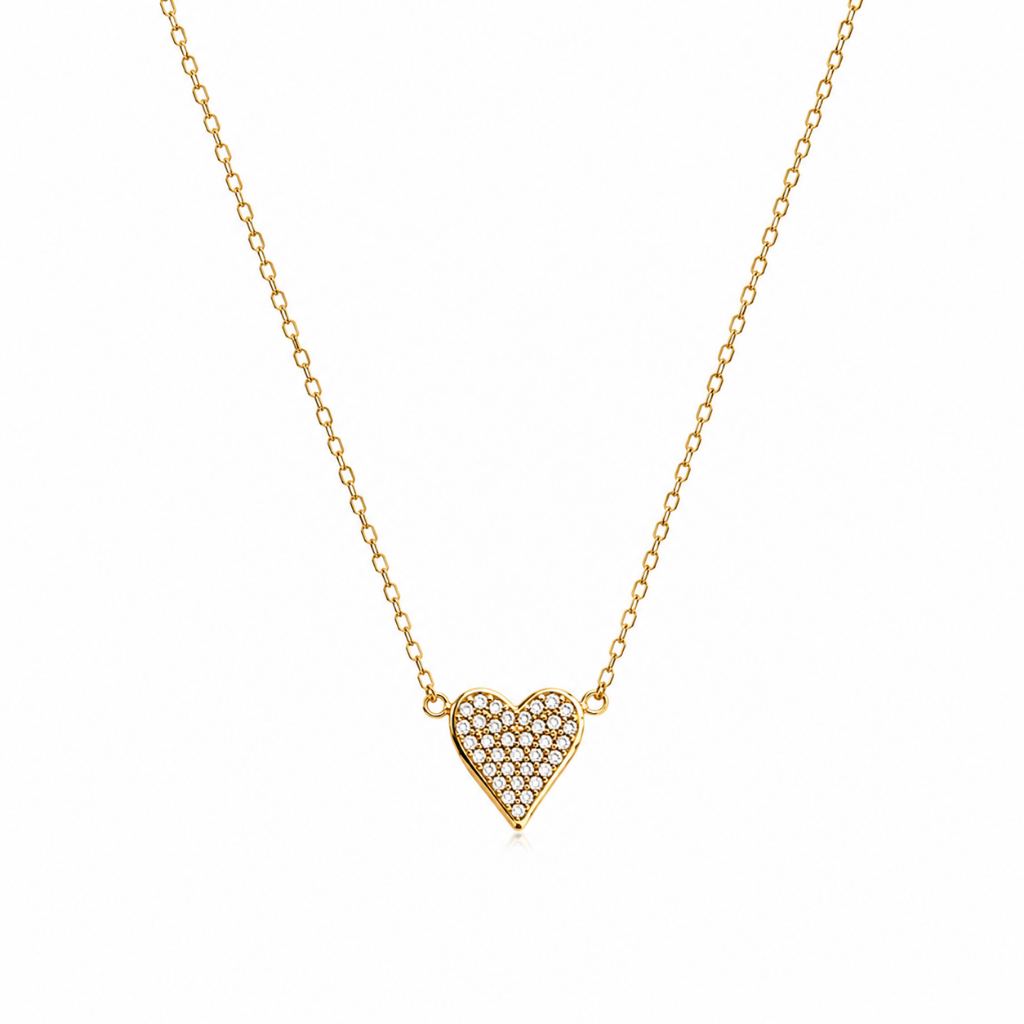 A delicate gold chain necklace featuring a small heart-shaped pendant paved with clear stones, displayed against a solid white background.