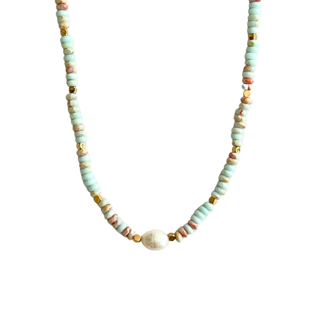 A beaded necklace featuring light mint green disc beads, small gold spacer beads, and a central white oval bead, displayed against a solid white background.