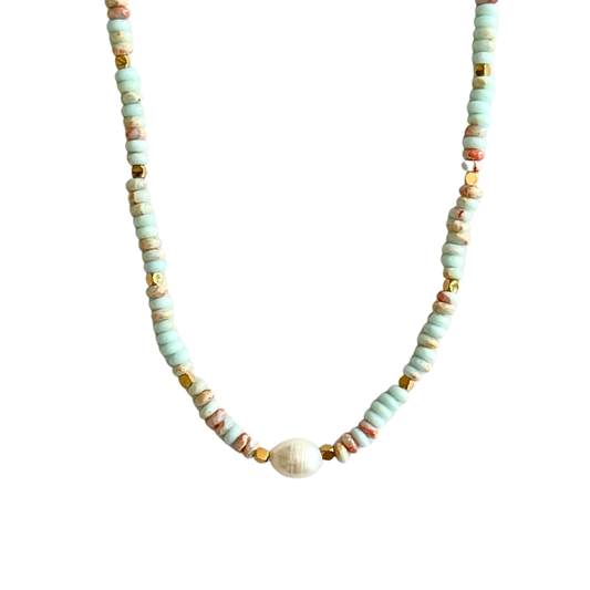 A beaded necklace featuring light mint green disc beads, small gold spacer beads, and a central white oval bead, displayed against a solid white background.