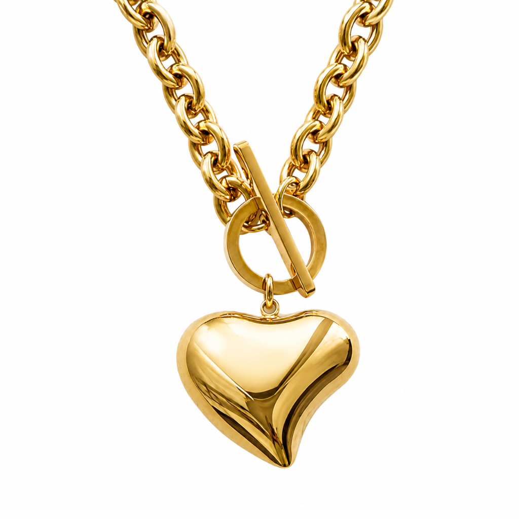 A gold heart-shaped pendant necklace with a toggle clasp on a matching curb chain, shown against a solid white background.