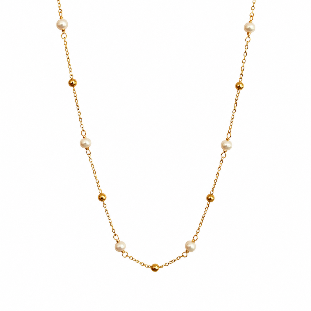 A delicate gold chain necklace featuring alternating small gold beads and white freshwater pearls, displayed against a solid white background.