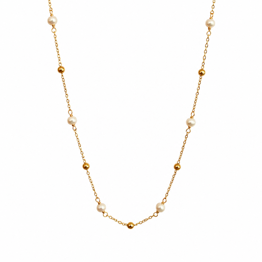 A delicate gold chain necklace featuring alternating small gold beads and white freshwater pearls, displayed against a solid white background.