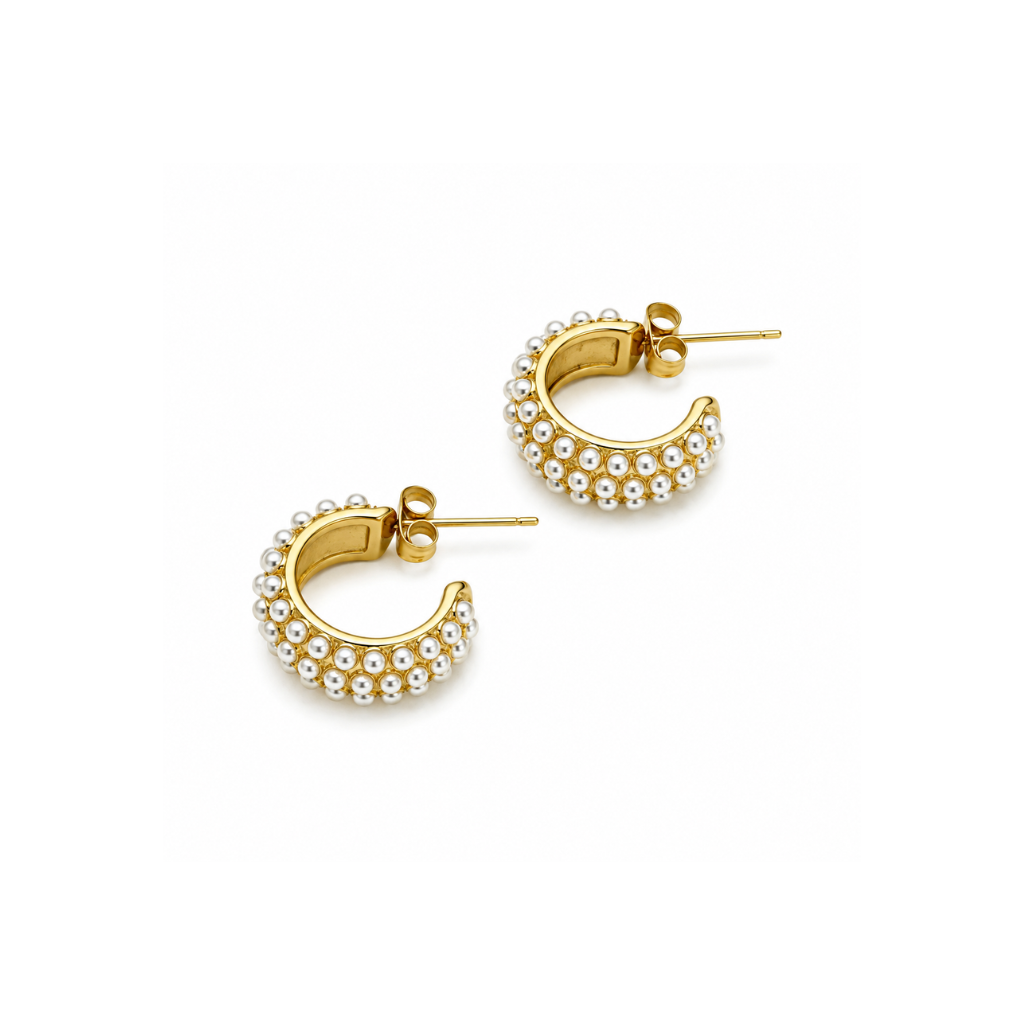 A pair of gold crescent-shaped hoop earrings embellished with rows of small white pearls, shown on a clean white background.